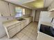 Well-lit kitchen featuring tile floors, classic cabinetry, and neutral countertops at 311 Sea Hawk Ct, Edgewater, FL 32141