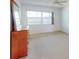 Bedroom with light-colored carpet, large window, and a dresser with a mirror at 315 N Causeway # 405, New Smyrna Beach, FL 32169