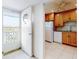 Bright kitchen with granite countertops, wooden cabinets, tile floors, and white appliances is seen from the home's entrance at 315 N Causeway # 405, New Smyrna Beach, FL 32169