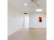 Bright living room featuring neutral walls and carpet, ceiling fan, and entry to kitchen at 315 N Causeway # 405, New Smyrna Beach, FL 32169