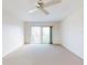 Bright living room with a ceiling fan and sliding glass doors to the balcony offers plenty of natural light at 315 N Causeway # 405, New Smyrna Beach, FL 32169