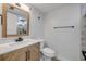 Bathroom featuring a wood vanity with a marble countertop, modern fixtures and a tiled shower at 325 N Causeway # B101, New Smyrna Beach, FL 32169