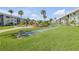 Beautifully landscaped condo courtyard featuring a shuffleboard court and lush tropical foliage at 325 N Causeway # B101, New Smyrna Beach, FL 32169