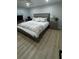 Bright bedroom with a comfortable bed, modern window shutters, and wood-look floors at 325 N Causeway # B101, New Smyrna Beach, FL 32169
