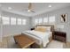 A well lit bedroom features a ceiling fan, a neutral color palette and shuttered windows at 325 N Causeway # B101, New Smyrna Beach, FL 32169
