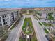 Aerial shot of a community entrance with a water feature, clock tower and colorful condominium buildings at 3368 Tuscano Ne Ave, New Smyrna Beach, FL 32168