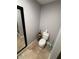 The half bathroom features neutral tile flooring, a toilet, and a full-length mirror at 3368 Tuscano Ne Ave, New Smyrna Beach, FL 32168