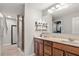 Bathroom featuring a large mirror, double vanity, marble countertops, and walk-in shower at 3368 Tuscano Ne Ave, New Smyrna Beach, FL 32168