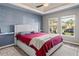 Cozy bedroom featuring a tray ceiling, two windows, and neutral-colored walls at 3368 Tuscano Ne Ave, New Smyrna Beach, FL 32168