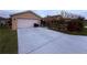 Long driveway leads to a two-car garage, complemented by side yard landscaping at 3368 Tuscano Ne Ave, New Smyrna Beach, FL 32168