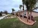 Well-manicured lawn and landscaping featuring palm trees and decorative rock beds at 3368 Tuscano Ne Ave, New Smyrna Beach, FL 32168