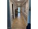 Hallway with tile flooring, wainscoting, and decorative accents, leading to a front door with glass panel at 3368 Tuscano Ne Ave, New Smyrna Beach, FL 32168