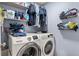 Functional laundry room with washer, dryer, shelving, and storage baskets at 3368 Tuscano Ne Ave, New Smyrna Beach, FL 32168