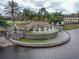 The Venetian Bay entrance features an intricate tiered fountain amidst lush landscaping, creating a welcoming ambiance at 3368 Tuscano Ne Ave, New Smyrna Beach, FL 32168