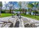 Backyard with a view of the lake, shaded by trees, featuring a patio with lounge chairs and a grill at 3783 Sweet Grove Ct, Port Orange, FL 32129