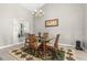 Dining area features a chandelier, light gray walls, a glass table, seating for four, and light gray wood-look floors at 3783 Sweet Grove Ct, Port Orange, FL 32129