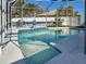 Screened-in pool featuring a white frame, blue tile trim, and clear, inviting water on a sunny day at 3783 Sweet Grove Ct, Port Orange, FL 32129