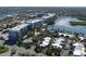 Aerial view showcasing the neighborhood with lush greenery, waterfront access, and nearby buildings at 43 Jacaranda Cay Ct # 430, New Smyrna Beach, FL 32169