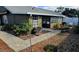 Backyard featuring a brick pathway, lush landscaping, and a charming sunroom extension at 45 Sandra Cir, New Smyrna Beach, FL 32168