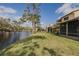 Lush green backyard with pond access and screened patio, offering a peaceful outdoor living space with scenic water views at 456 Shorewood Ln, New Smyrna Beach, FL 32168