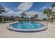 Community pool with inviting blue water, ample lounge chairs, palm trees, and a glimpse of surrounding neighborhood at 456 Shorewood Ln, New Smyrna Beach, FL 32168