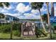 Charming wood dock leads to the waterfront, surrounded by lush greenery and blue skies at 47 Jacaranda Cay Ct # 470, New Smyrna Beach, FL 32169