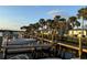 Waterfront property featuring a dock, boat slips, and waterfront condos surrounded by palm trees at 47 Jacaranda Cay Ct # 470, New Smyrna Beach, FL 32169