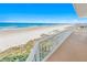 Balcony featuring ocean views, white railing, and a beach access point at 4767 S Atlantic Ave # 404, Ponce Inlet, FL 32127