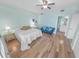 Well-lit bedroom with hardwood floors, a bed, and a futon, leading to an ensuite bathroom at 4767 S Atlantic Ave # 404, Ponce Inlet, FL 32127