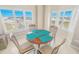 Bright dining area with a round table, chairs, and a view from the wide windows at 4767 S Atlantic Ave # 404, Ponce Inlet, FL 32127