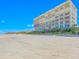 Exterior view of the beachfront condo building and surrounding beach at 4767 S Atlantic Ave # 404, Ponce Inlet, FL 32127