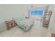 Bright bedroom featuring a king bed, tile floors, ceiling fan and sliding glass doors to the balcony with ocean views at 4767 S Atlantic Ave # 404, Ponce Inlet, FL 32127