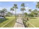 Well-maintained backyard with a private wooden walkway leading to the waterfront and lush tropical landscaping at 49 Jacaranda Cay Ct # 49, New Smyrna Beach, FL 32169