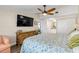 Well-lit bedroom featuring a woven dresser, flat-screen TV, and ensuite bathroom at 49 Jacaranda Cay Ct # 49, New Smyrna Beach, FL 32169