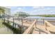 Picturesque dock extends into the calm waterway with waterfront condos in the background at 49 Jacaranda Cay Ct # 49, New Smyrna Beach, FL 32169