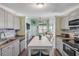 Kitchen and living room featuring stainless steel appliances, island seating and a cozy seating area at 49 Jacaranda Cay Ct # 49, New Smyrna Beach, FL 32169