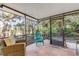 Screened porch with a seating area surrounded by beautiful green landscaping at 49 Jacaranda Cay Ct # 49, New Smyrna Beach, FL 32169