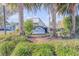 Entrance to Dolphin Cove, framed by palm trees and vibrant landscaping at 49 Jacaranda Cay Ct # 49, New Smyrna Beach, FL 32169