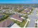 Aerial view of a community with houses boasting screened pools and lush landscaping, near a picturesque lake at 512 Romdini St, New Smyrna Beach, FL 32168