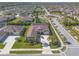 Aerial view of a house boasting manicured landscaping and mature palm trees within a quiet residential neighborhood at 512 Romdini St, New Smyrna Beach, FL 32168