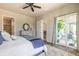 Bright bedroom features a ceiling fan, ensuite bathroom, and sliding glass doors to the lanai at 512 Romdini St, New Smyrna Beach, FL 32168