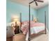 Comfortable bedroom features a four-poster bed, a ceiling fan, and light blue walls at 512 Romdini St, New Smyrna Beach, FL 32168