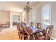 Formal dining room featuring wood furniture, chandelier and a large window with shutter at 512 Romdini St, New Smyrna Beach, FL 32168