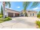 Stunning beige stucco home with a three-car garage, arched entry, and beautiful tropical landscaping at 512 Romdini St, New Smyrna Beach, FL 32168