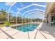 View of a sparkling screened-in pool area surrounded by lush landscaping and blue skies at 512 Romdini St, New Smyrna Beach, FL 32168