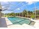 Inviting screened-in pool with a seating area and clear blue skies reflecting in the water at 512 Romdini St, New Smyrna Beach, FL 32168