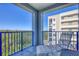 Outdoor balcony with blue railings featuring views of nearby building and natural landscape at 5300 S Atlantic Ave # 5-407, New Smyrna Beach, FL 32169