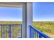 Balcony view showing a natural green space, a blue railing, and a blue sky in the distance at 5300 S Atlantic Ave # 5-407, New Smyrna Beach, FL 32169