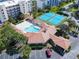 Aerial view of a community pool, clubhouse, tennis courts, parking and nicely landscaped grounds at 5300 S Atlantic Ave # 5-407, New Smyrna Beach, FL 32169