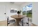 Cozy dining area featuring a round wood table, seating for four, and bright natural light from a large window at 5431 Landis Ave, Port Orange, FL 32127